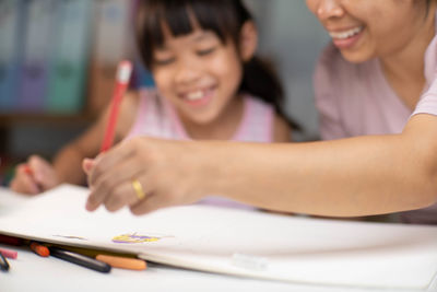 Young woman drawing on book at home