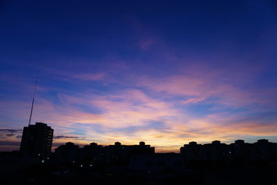 Silhouette buildings against sky during sunset