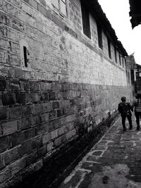 People walking on cobblestone street in city