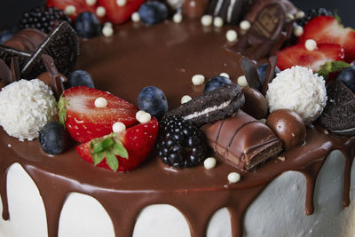 Cake decorated with strawberry and chocolate on dark background