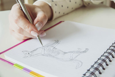 Woman drawing a dog with a pencil