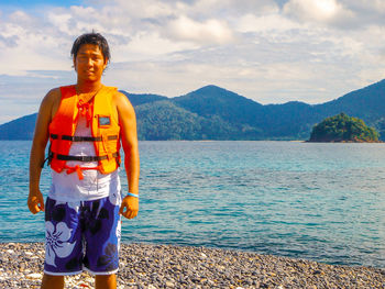 Portrait of man standing in sea against sky