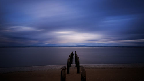 Scenic view of sea against cloudy sky during sunset