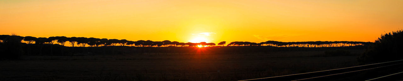 Scenic view of silhouette landscape against orange sky