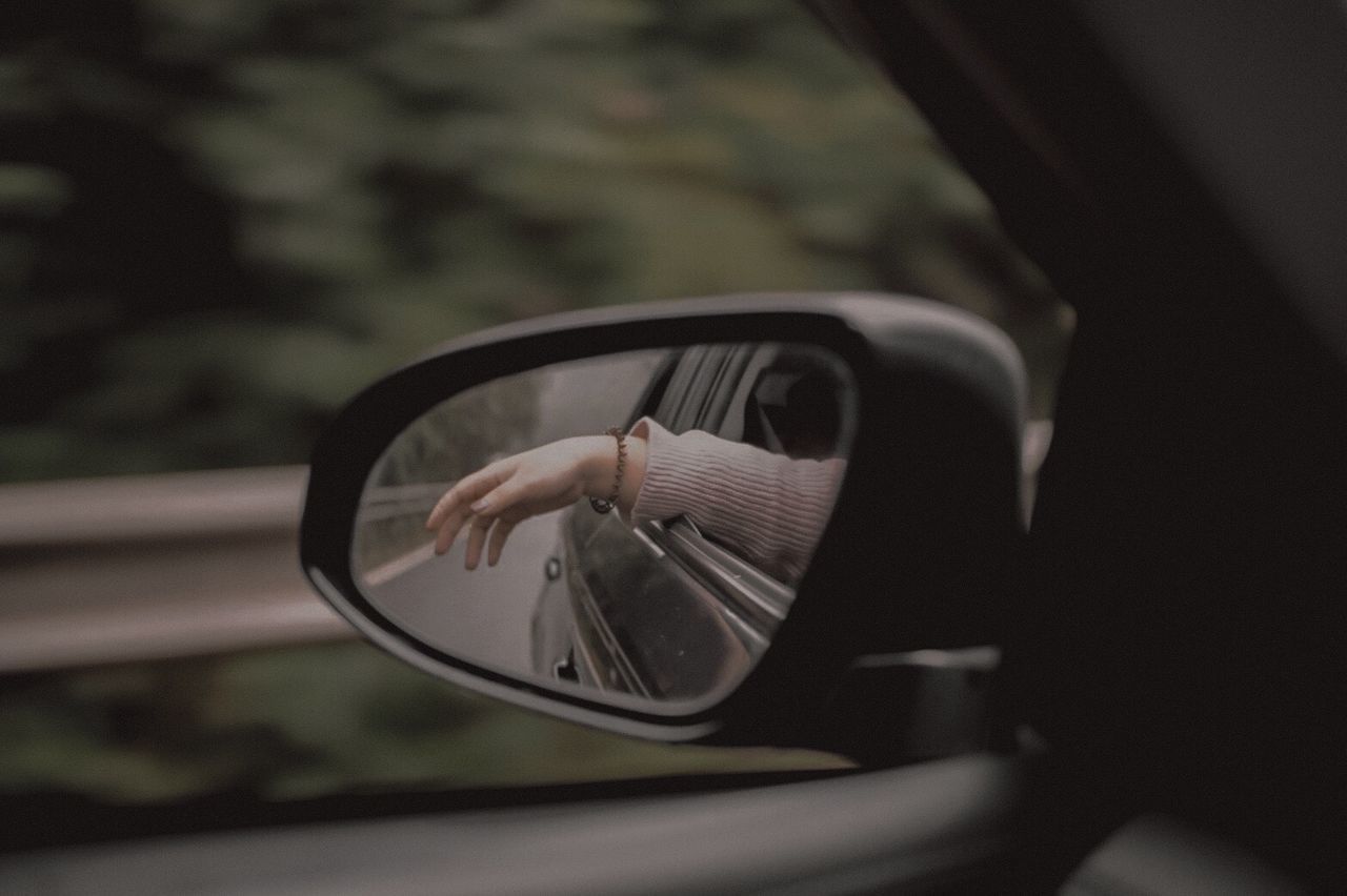 REFLECTION OF MAN ON SIDE-VIEW MIRROR