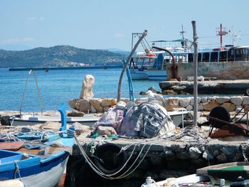 Boats moored at harbor against clear sky