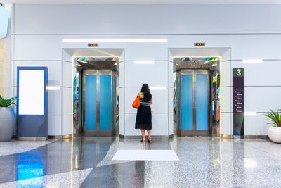 Full length rear view of woman walking on door
