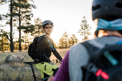 Friends chatting before early morning mountain bike ride