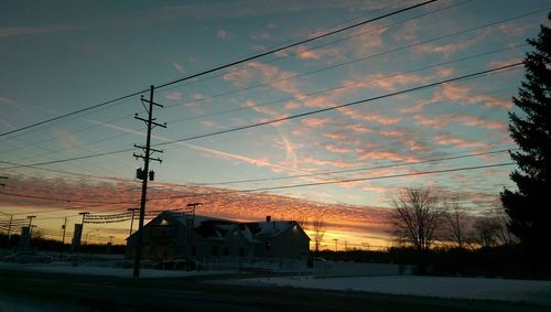 Electricity pylon against cloudy sky