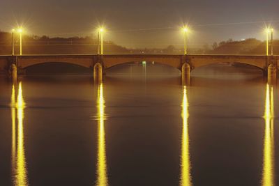 Illuminated bridge against sky at night