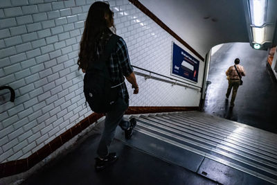 Rear view of woman walking on subway station