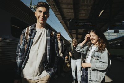 Happy family walking at railroad station during sunny day