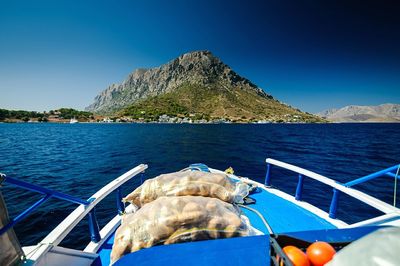 Close-up of boat sailing in sea against clear blue sky