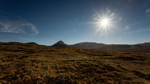 Scenic view of landscape against sky on sunny day