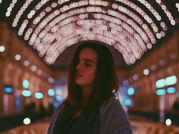 Close-up of woman with eyes closed at night