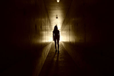 Silhouette woman standing in tunnel