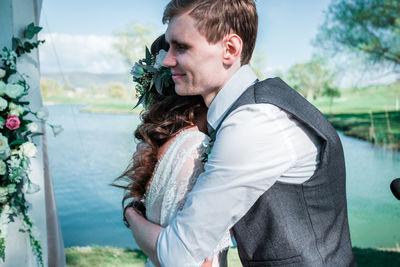 Side view of young man looking at camera