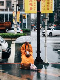 Man with umbrella on street during rainy season