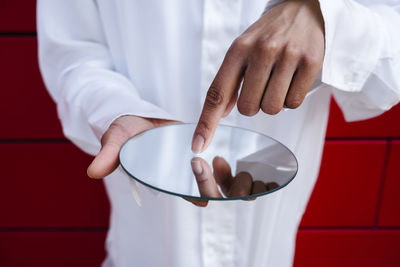 Midsection of doctor holding dentures