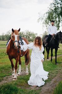 Couple riding horse on field