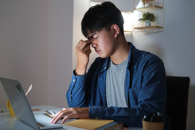 Man using mobile phone while sitting on table