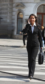 Full length of a smiling woman in city