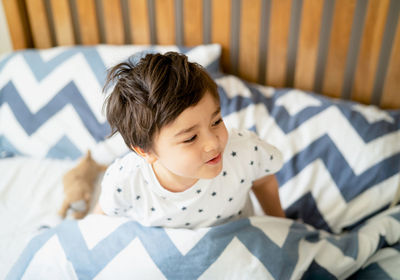 Boy lying on bed at home