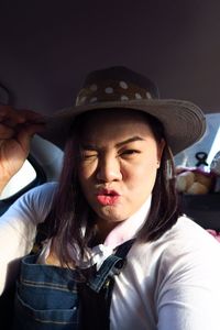 Close-up portrait of woman wearing hat sitting in car