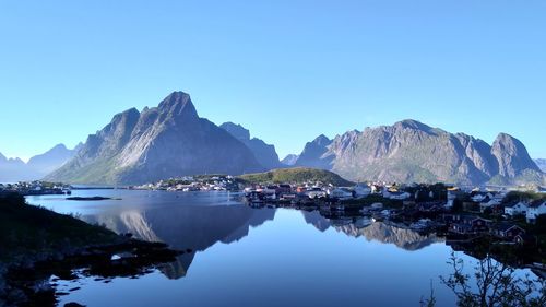 Scenic view of lake and mountains against clear blue sky