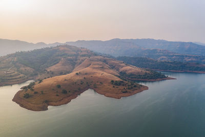 High angle view of sea and mountains against sky