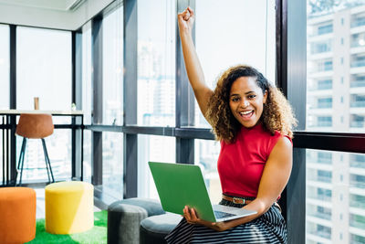 Portrait of smiling young woman using mobile phone