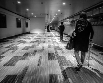 People walking in illuminated corridor