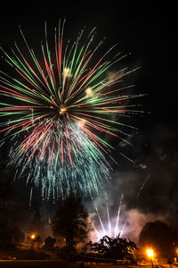 Low angle view of firework display at night