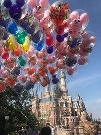 Low angle view of balloons hanging against sky