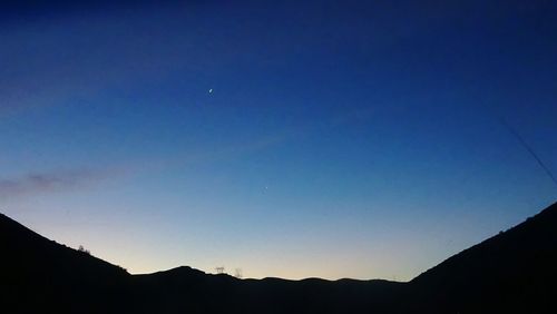 Low angle view of mountain against blue sky