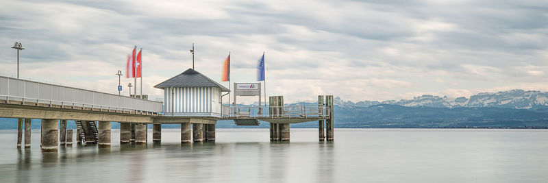 Pier at the lake contance against the alps