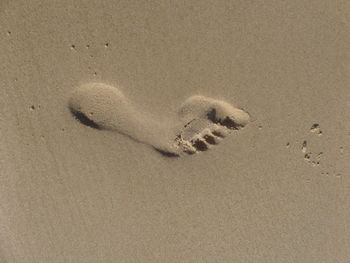 High angle view of footprints on sand at beach