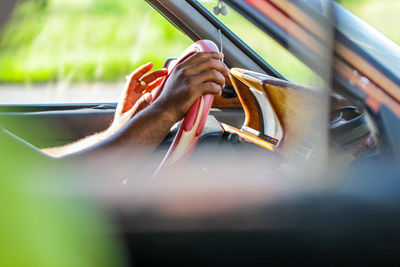 Cropped image of man smoking cigarette while driving car