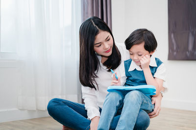 Mother and daughter sitting at home