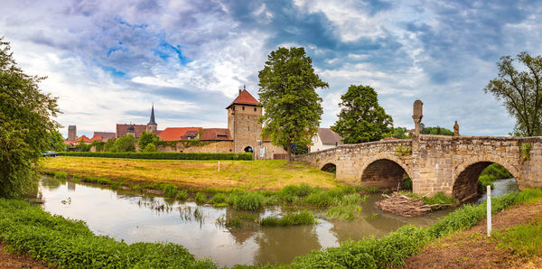 Arch bridge over river against sky