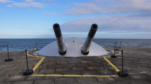 Canons on pier against sky
