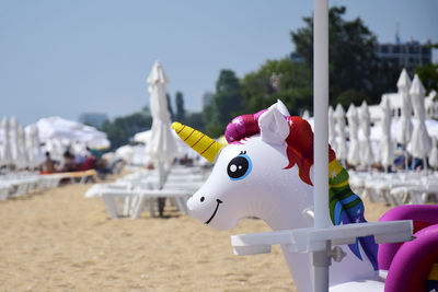 Children's inflatable colorful toy unicorn on background of beach umbrellas. close-up