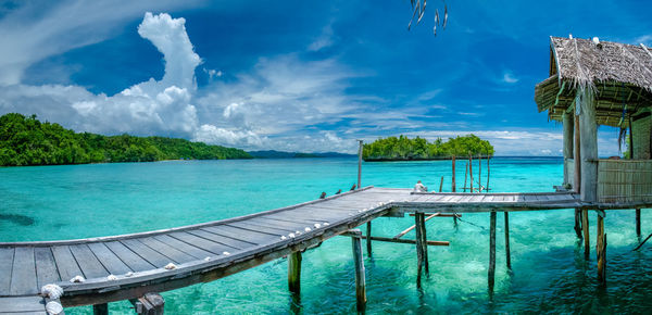 Panoramic view of swimming pool by sea against sky