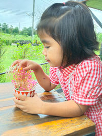 Girl holding ice cream on table