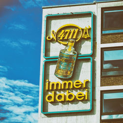 Low angle view of sign on building against sky