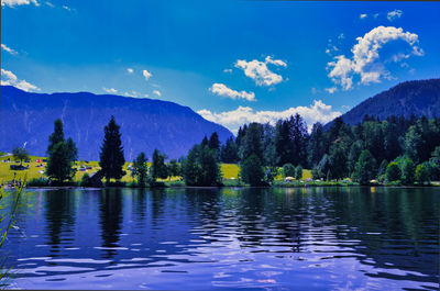 Scenic view of lake by mountains against sky