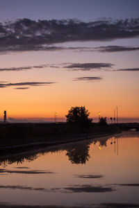 Scenic view of lake against orange sky