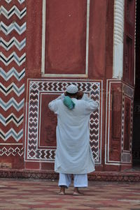 Rear view of man standing against wall