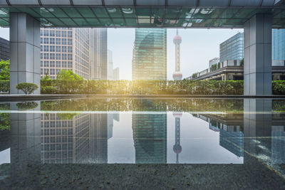 Reflection of buildings on swimming pool against sky