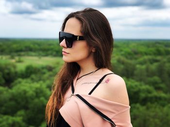 Portrait of woman wearing sunglasses against sky